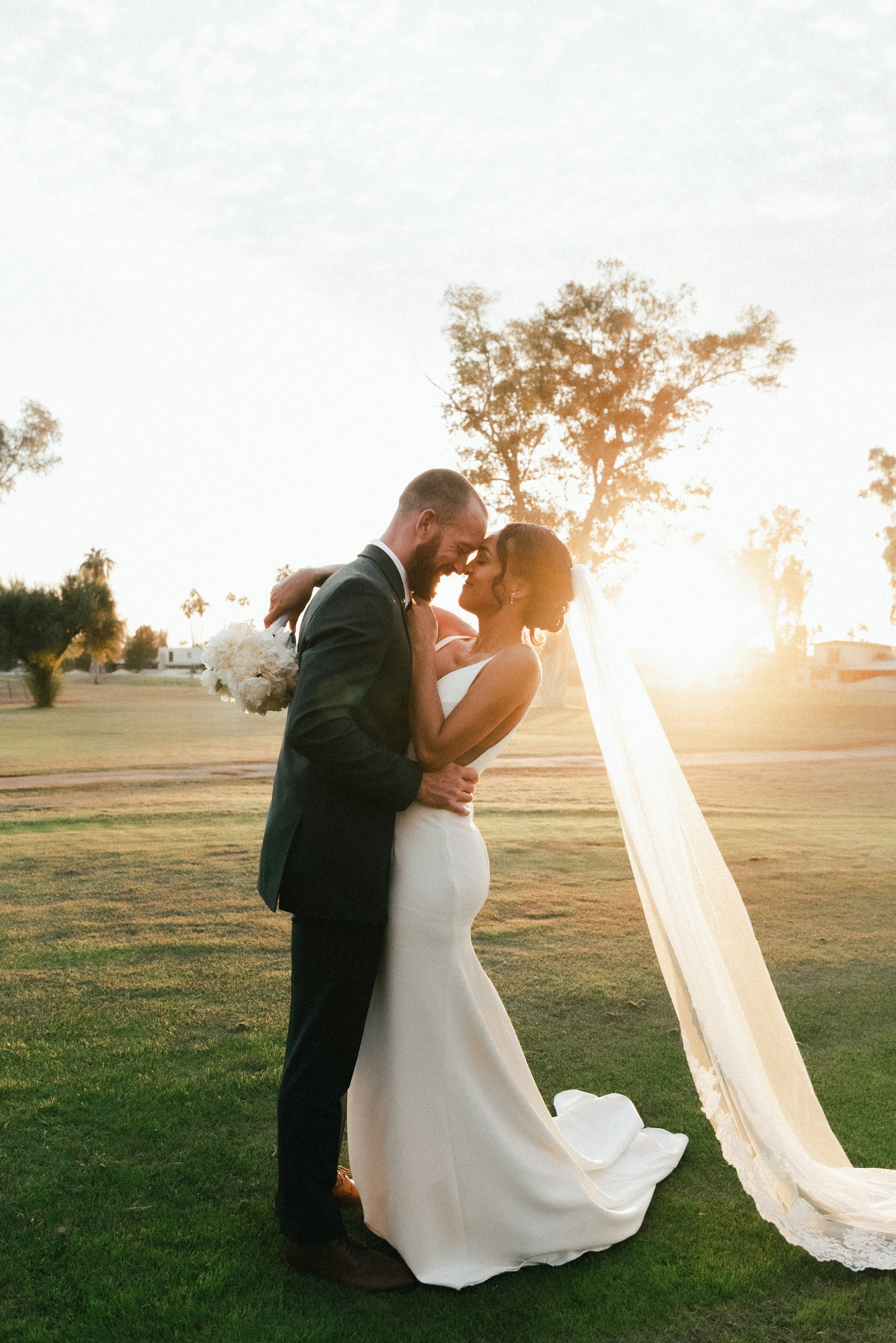 Couple kissing in a field at sunset