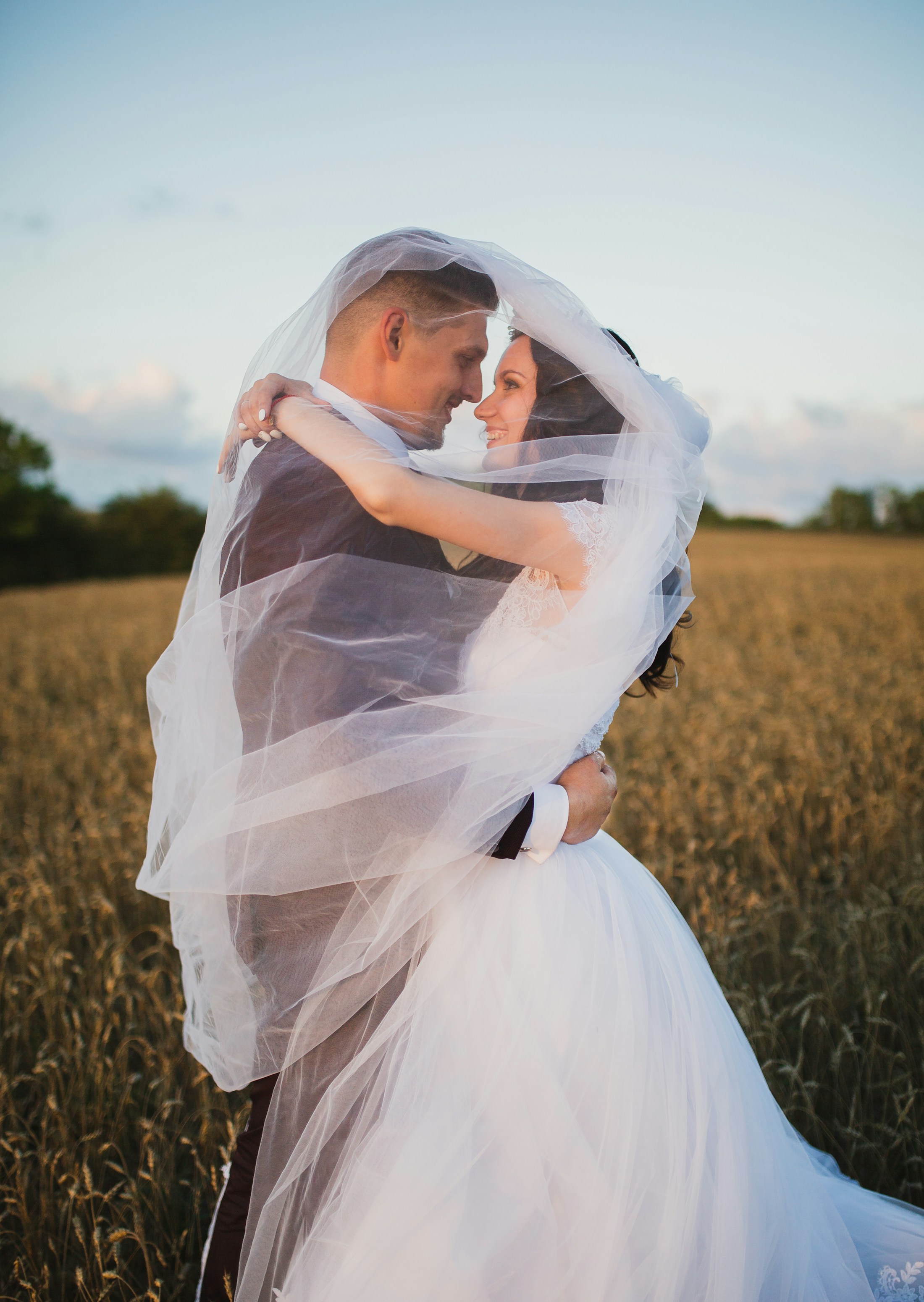 Smiling newlyweds in a green field